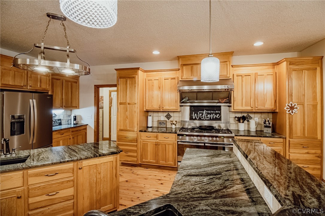 6809 West Quaker Road Disputanta, VA 23842 - Photo 6 of 49 a kitchen with stainless steel appliances granite countertop a stove top oven a sink and a refrigerator