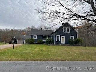 a view of a yard in front of a brick house with large windows