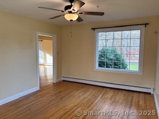 175 Pine Street Columbia, CT 06237 - Photo 14 of 29 an empty room with wooden floor chandelier fan and windows