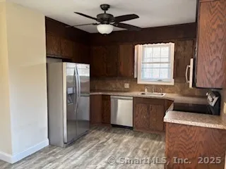 a kitchen with granite countertop a refrigerator a sink a stove and cabinets