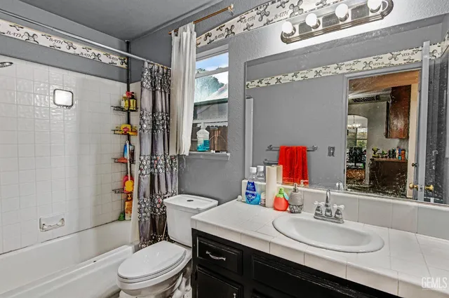 a bathroom with a sink vanity mirror and toilet