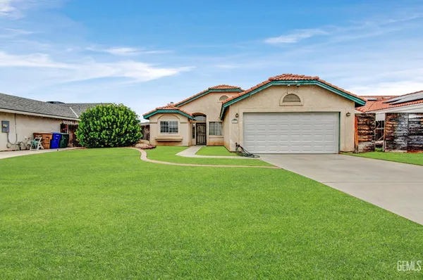 a front view of a house with a garden and yard
