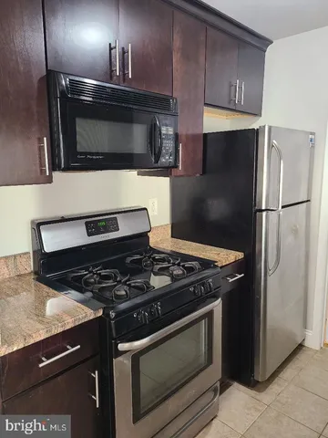a kitchen with stainless steel appliances granite countertop a stove microwave and refrigerator