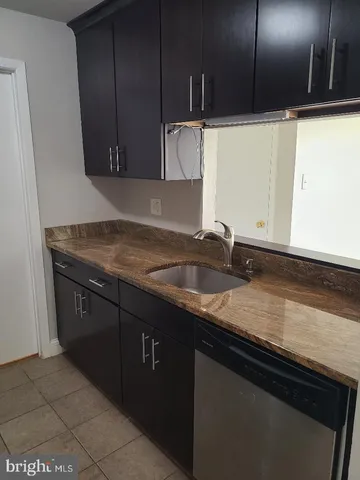 a kitchen with granite countertop a sink and cabinets