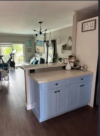 a view of a kitchen counter space a sink wooden floor and windows