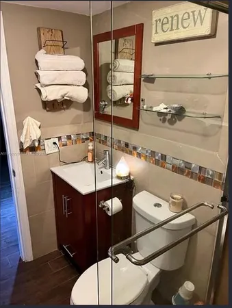 a bathroom with a sink mirror vanity and toilet