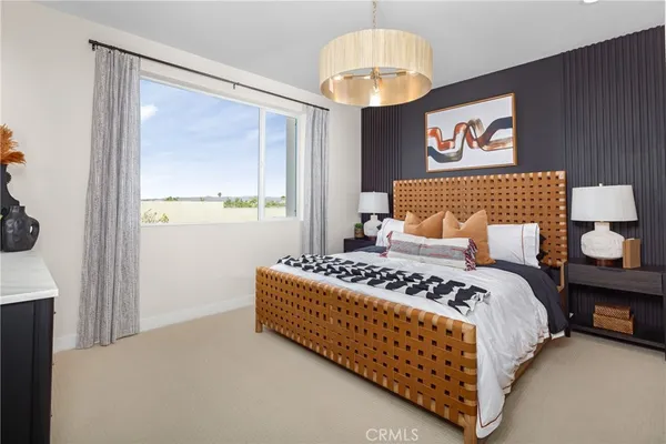 a bedroom with a bed chandelier and window