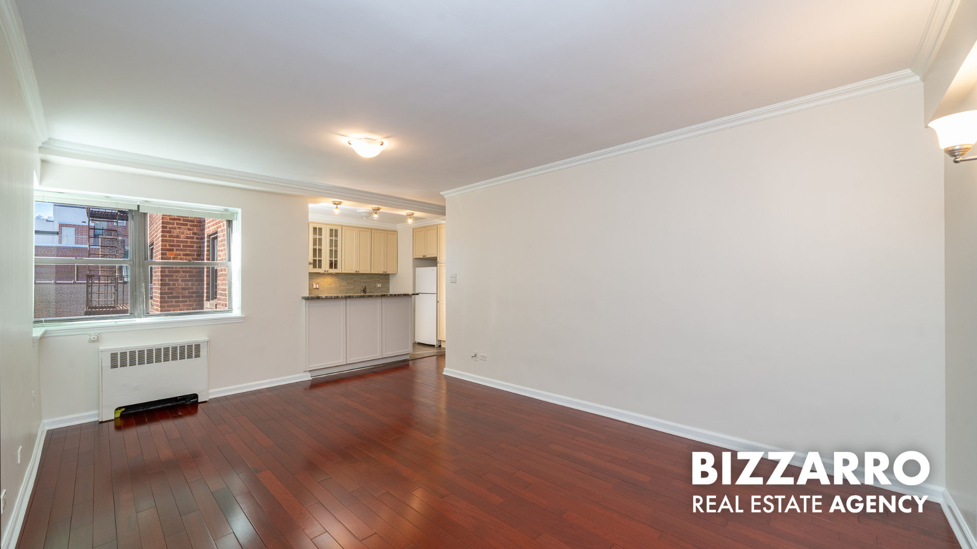 25-10 31st Avenue, Unit 5G Queens, NY 11106 - Photo 3 of 14 an empty room with wooden floor and windows