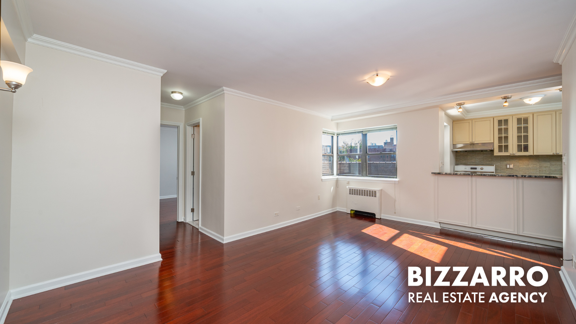 25-10 31st Avenue, Unit 5G Queens, NY 11106 - Photo 4 of 14 a view of an empty room with wooden floor and a window