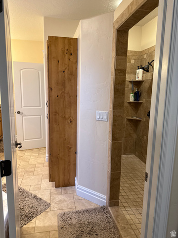 3145 South 500 West Vernal, UT 84078 - Photo 42 of 64 Bathroom with a tile shower, a textured wall, light tile patterned flooring, and a textured ceiling
