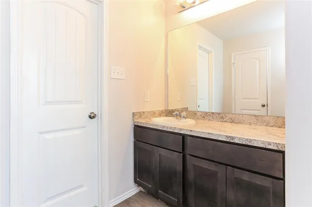a bathroom with a granite countertop sink and a mirror