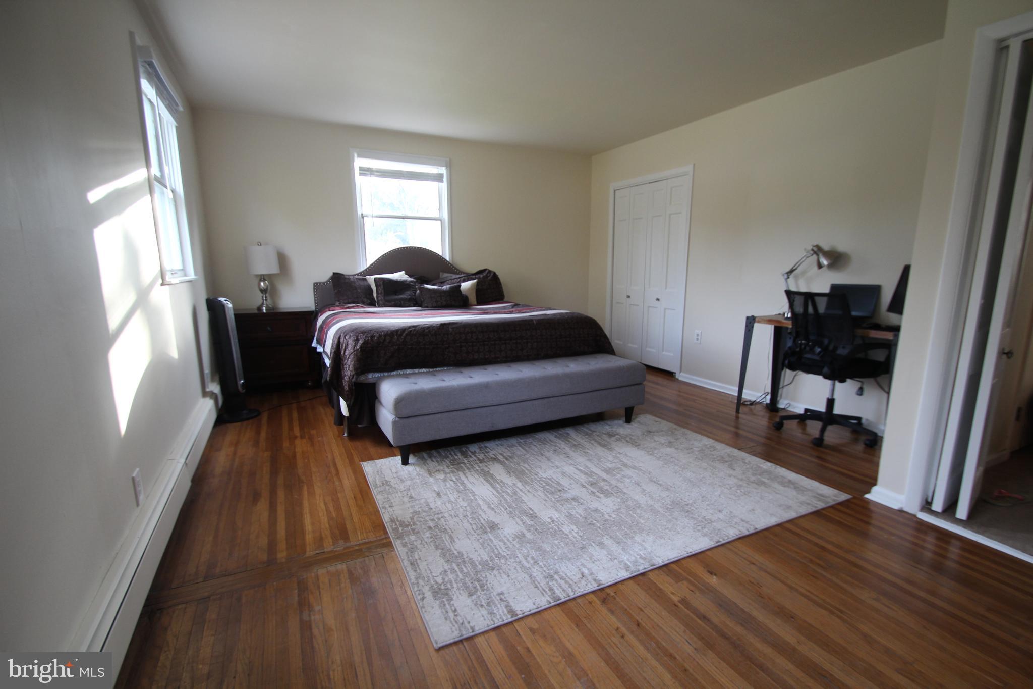 201 Spruce Road Flourtown, PA 19031 - Photo 14 of 39 a spacious bedroom with a bed and a dresser next to a window