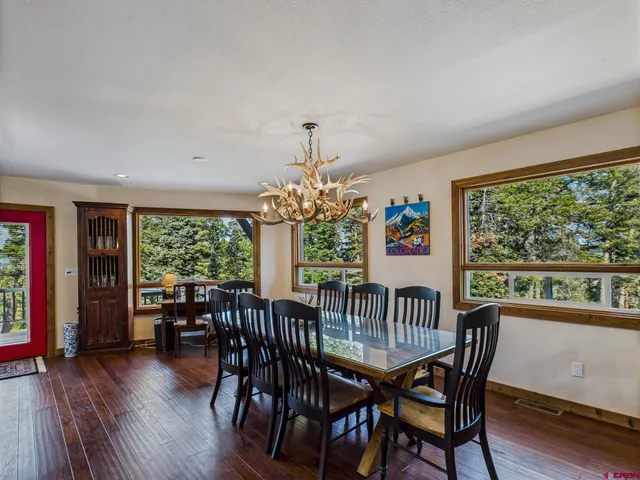 a living room filled with furniture a rug potted plant and a large window