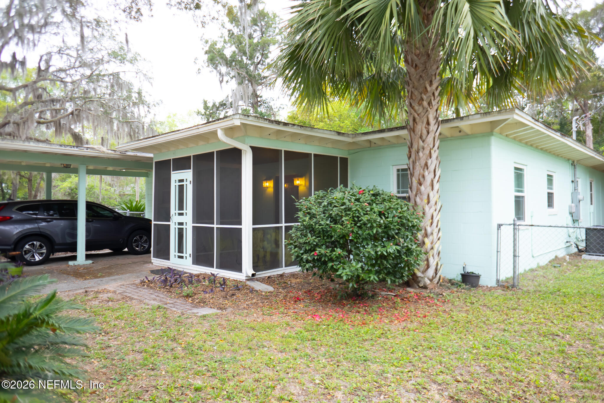 a view of a house with a yard and potted plants