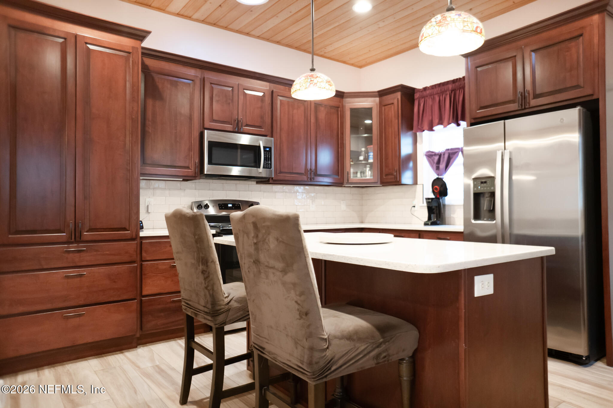 161 Southwest Jasmine Avenue Keystone Heights, FL 32656 - Photo 9 of 47 a kitchen with stainless steel appliances granite countertop a stove a refrigerator a microwave oven with a dining table and chairs
