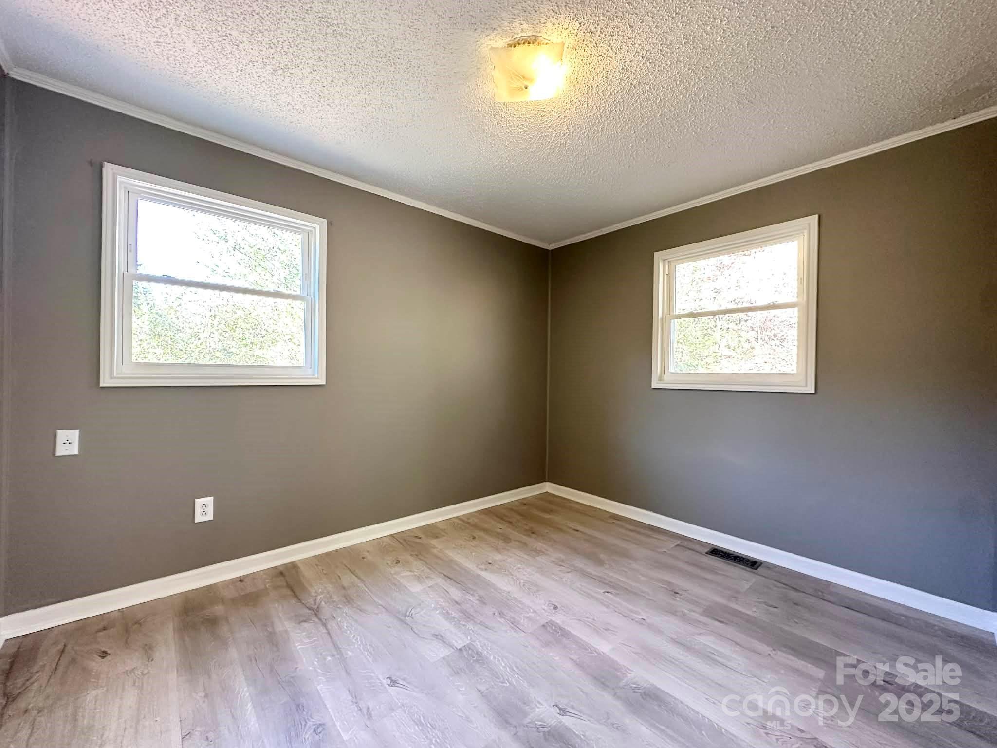 2238 Flatwood Road Lenoir, NC 28645 - Photo 11 of 12 a view of an empty room with wooden floor and a window