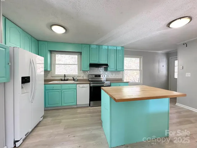 a kitchen with a refrigerator and a stove top oven
