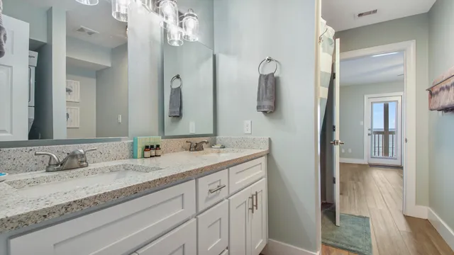 a bathroom with a granite countertop sink vanity and mirror