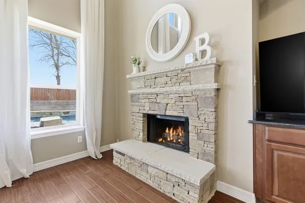 a living room with a fireplace a flat screen tv and a window