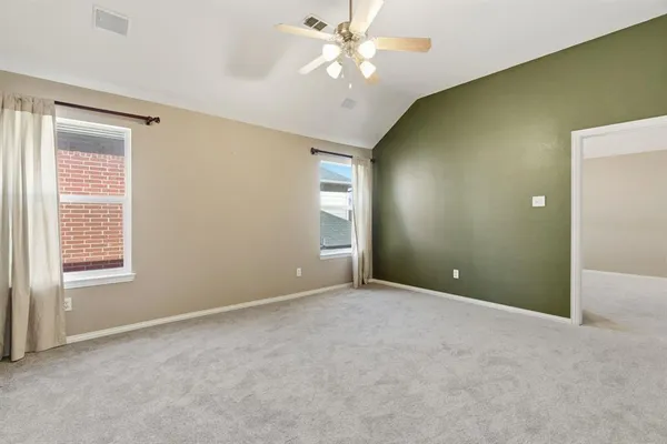 a view of an empty room with window and chandelier fan