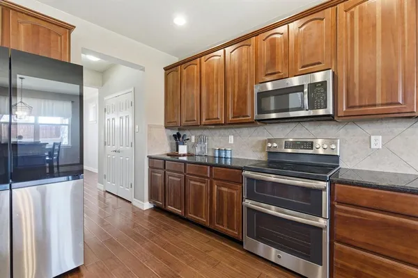 a kitchen with stainless steel appliances granite countertop a stove microwave and cabinets