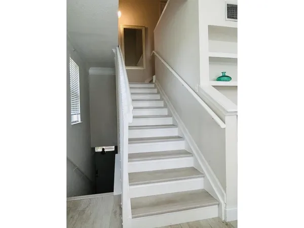a view of staircase with white walls and a window