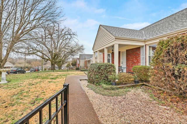 a view of a house with backyard and trees