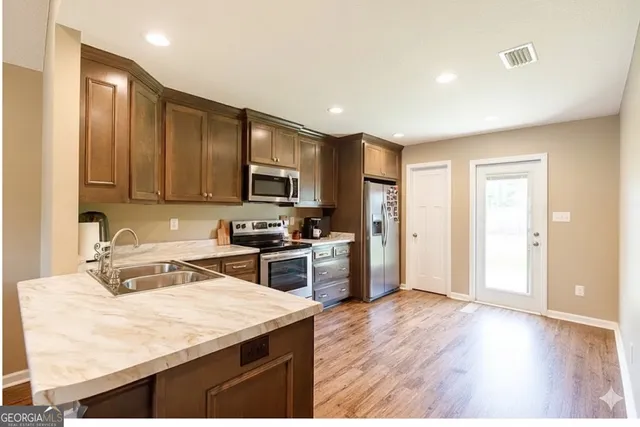 a kitchen with stainless steel appliances granite countertop a sink stove and refrigerator