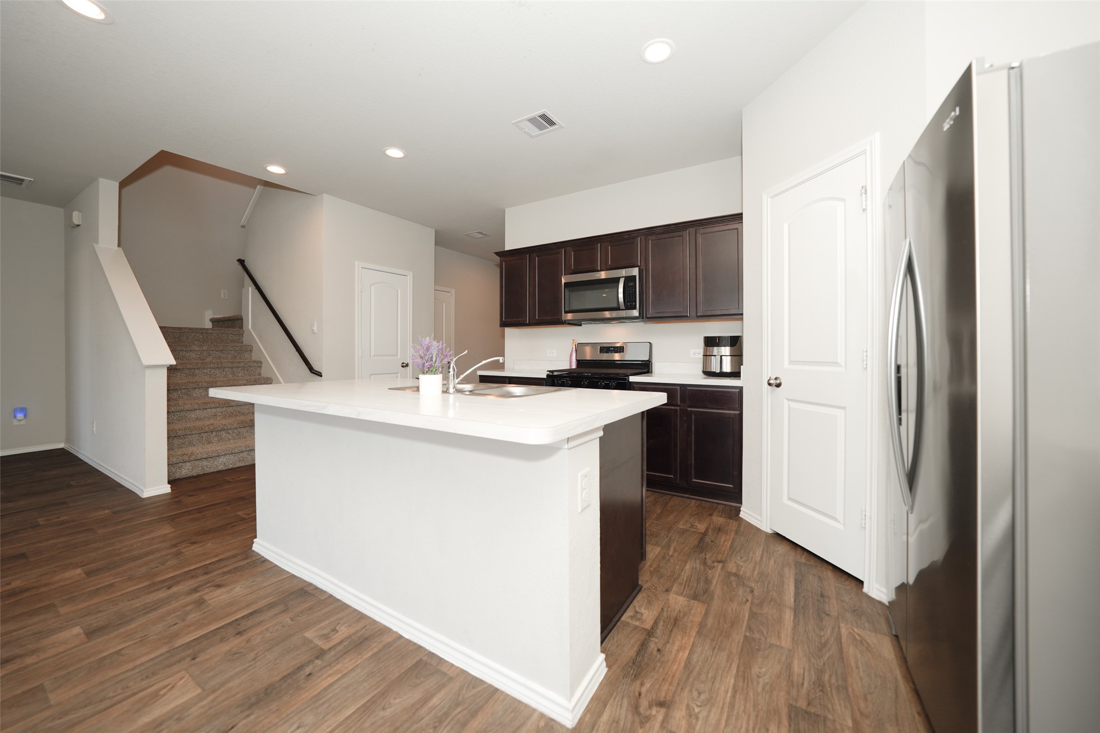 20818 Edmeston Way Katy, TX 77449 - Photo 19 of 32 a kitchen with kitchen island a sink a stove a refrigerator and a microwave