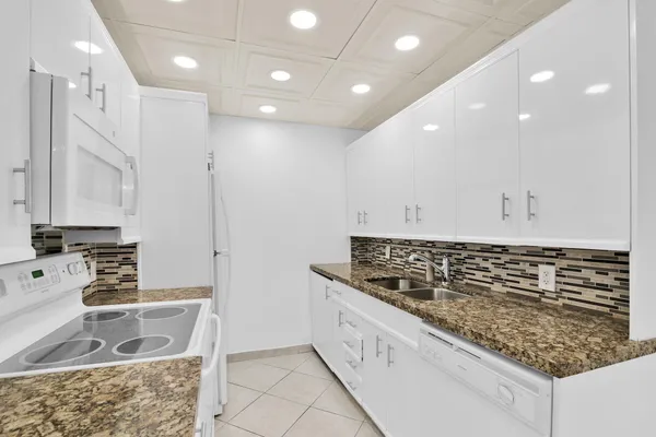 a kitchen with stainless steel appliances granite countertop a sink and cabinets