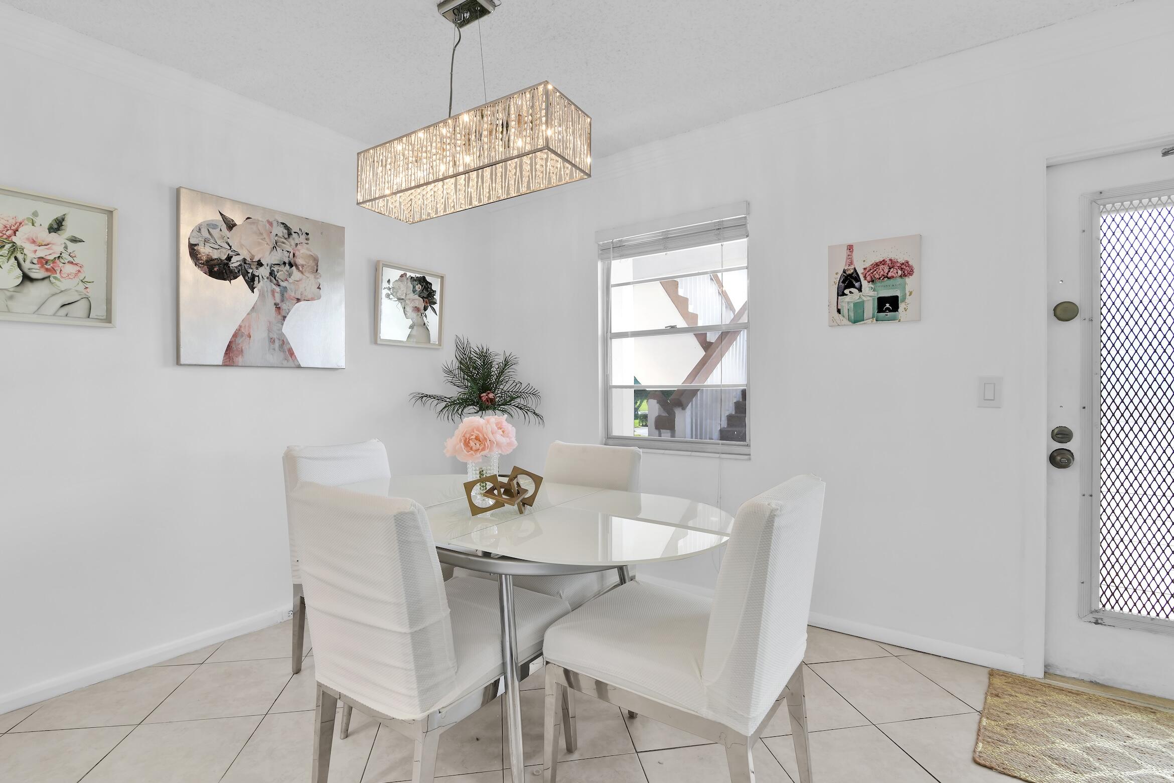 2043 Cornwall C, Unit 2043 Boca Raton, FL 33434 - Photo 5 of 22 a view of a dining room with furniture and chandelier