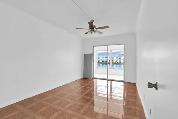 an empty room with windows and fan