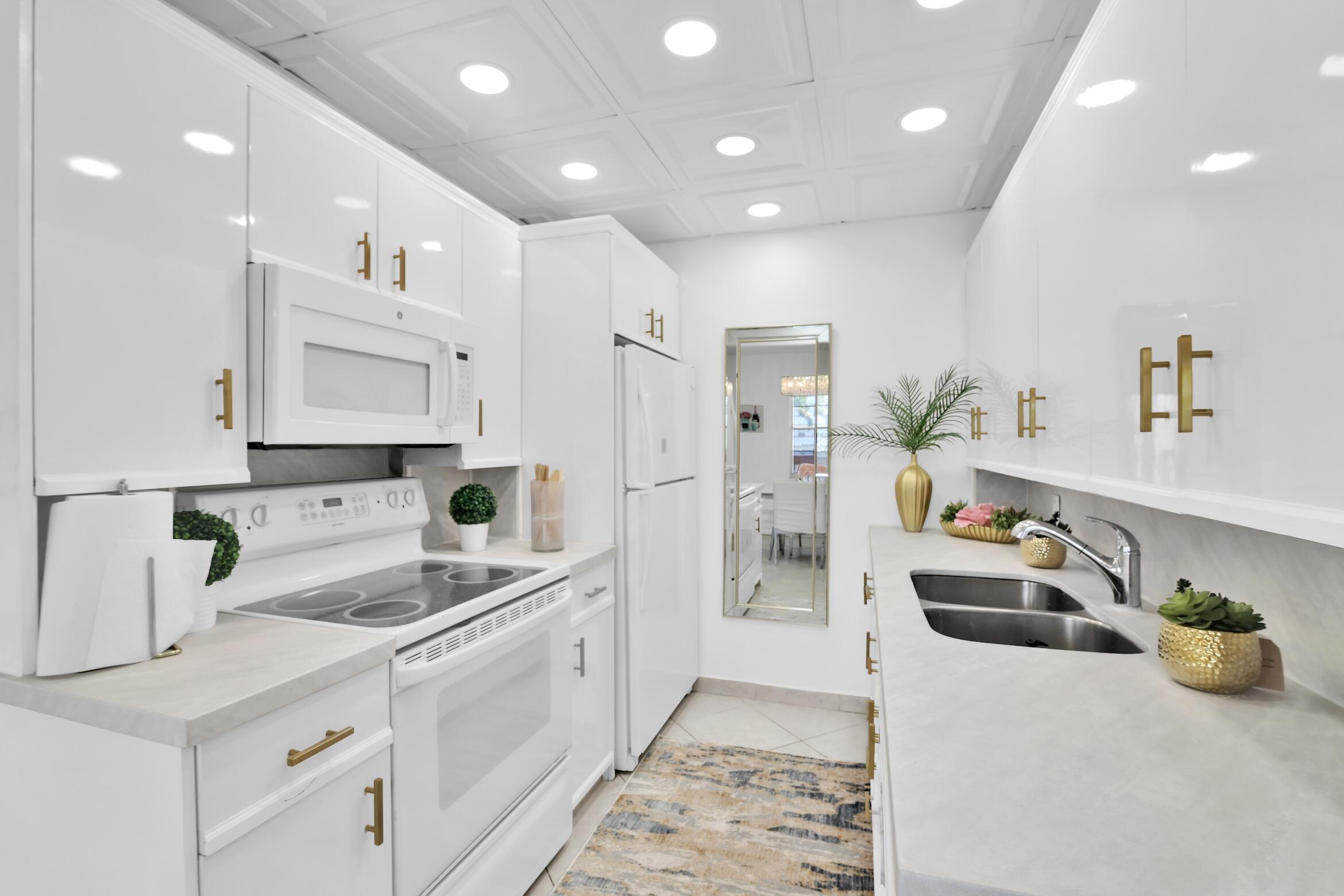 2043 Cornwall C, Unit 2043 Boca Raton, FL 33434 - Photo 9 of 22 a kitchen with a sink and white cabinets
