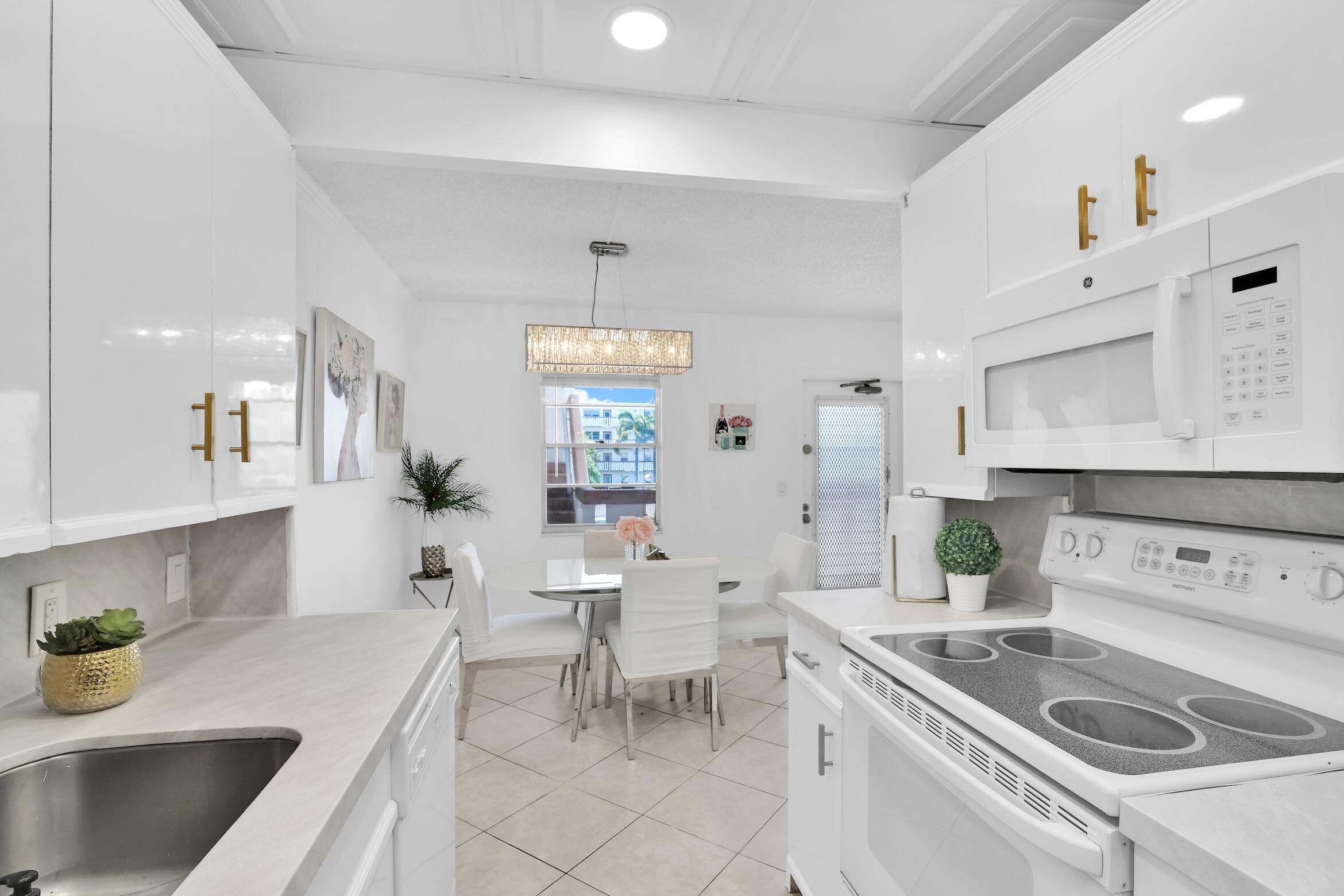 2043 Cornwall C, Unit 2043 Boca Raton, FL 33434 - Photo 10 of 22 a kitchen with a sink a stove and chairs