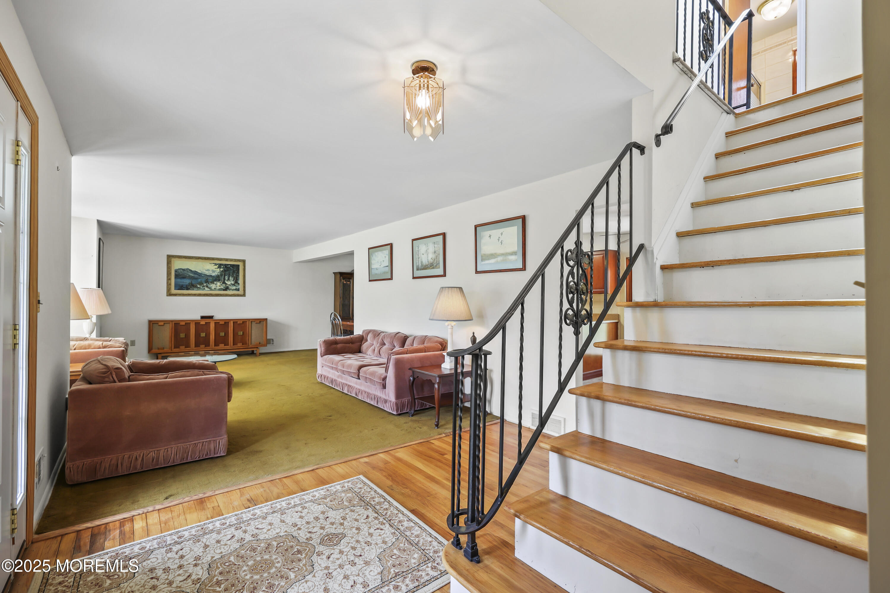 27 Sargent Road Freehold, NJ 07728 - Photo 16 of 47 a living room with furniture and a chandelier