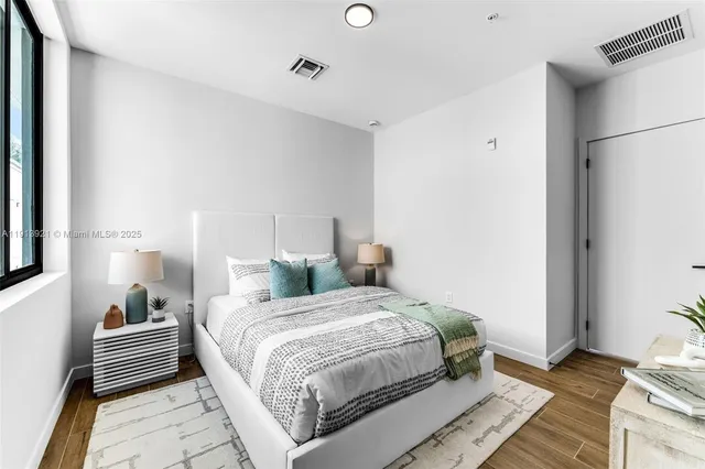 a bedroom with a bed and wooden floor