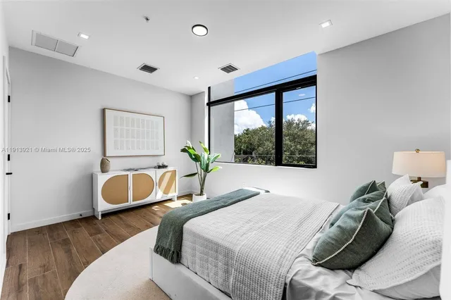 a bedroom with a bed and a large window