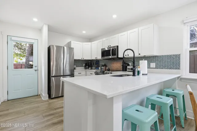 a kitchen with stainless steel appliances a refrigerator sink and cabinets