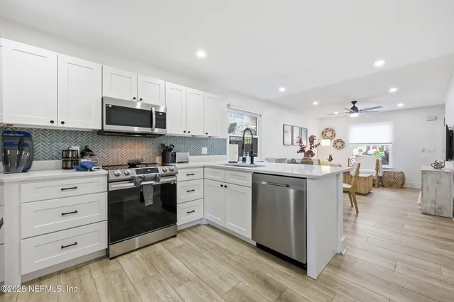 a kitchen with appliances a sink and cabinets