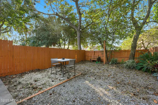 a view of a yard with plants and trees