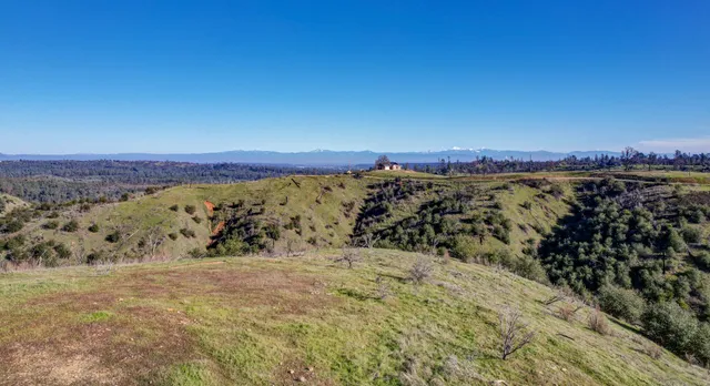 a view of mountain with sunset in background