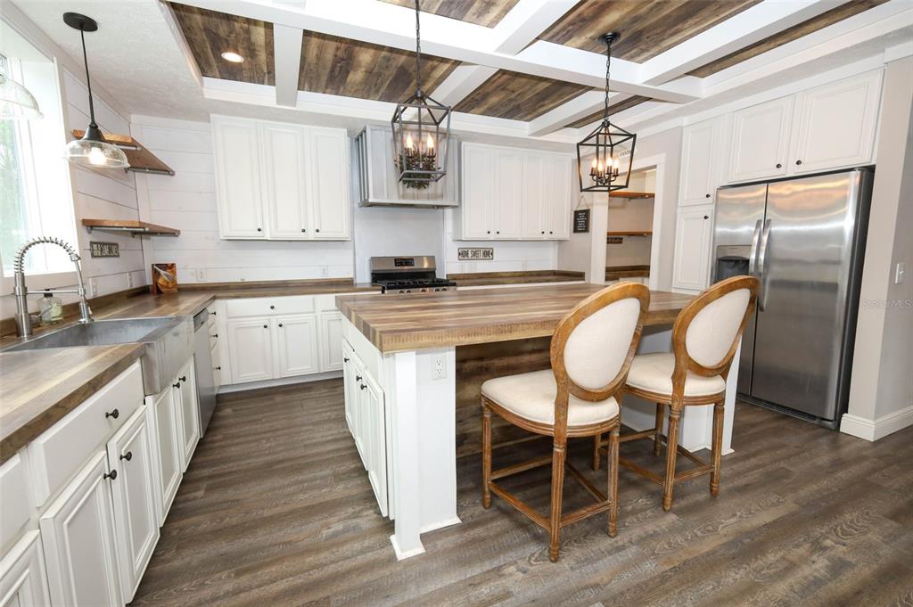 2269 Mullet Lake Park Road Geneva, FL 32732 - Photo 15 of 76 a kitchen with stainless steel appliances granite countertop a table chairs sink and cabinets