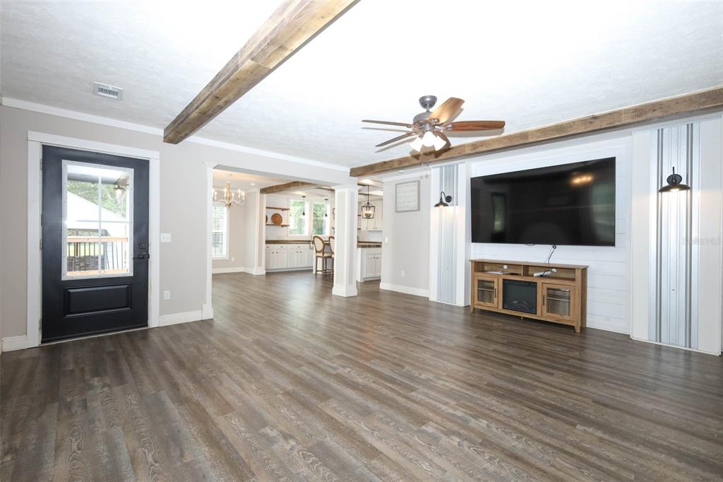 2269 Mullet Lake Park Road Geneva, FL 32732 - Photo 6 of 76 a view of a livingroom with a flat screen tv wooden floor and a ceiling fan