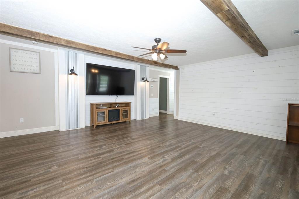 2269 Mullet Lake Park Road Geneva, FL 32732 - Photo 10 of 76 a view of a livingroom with wooden floor and a flat screen tv