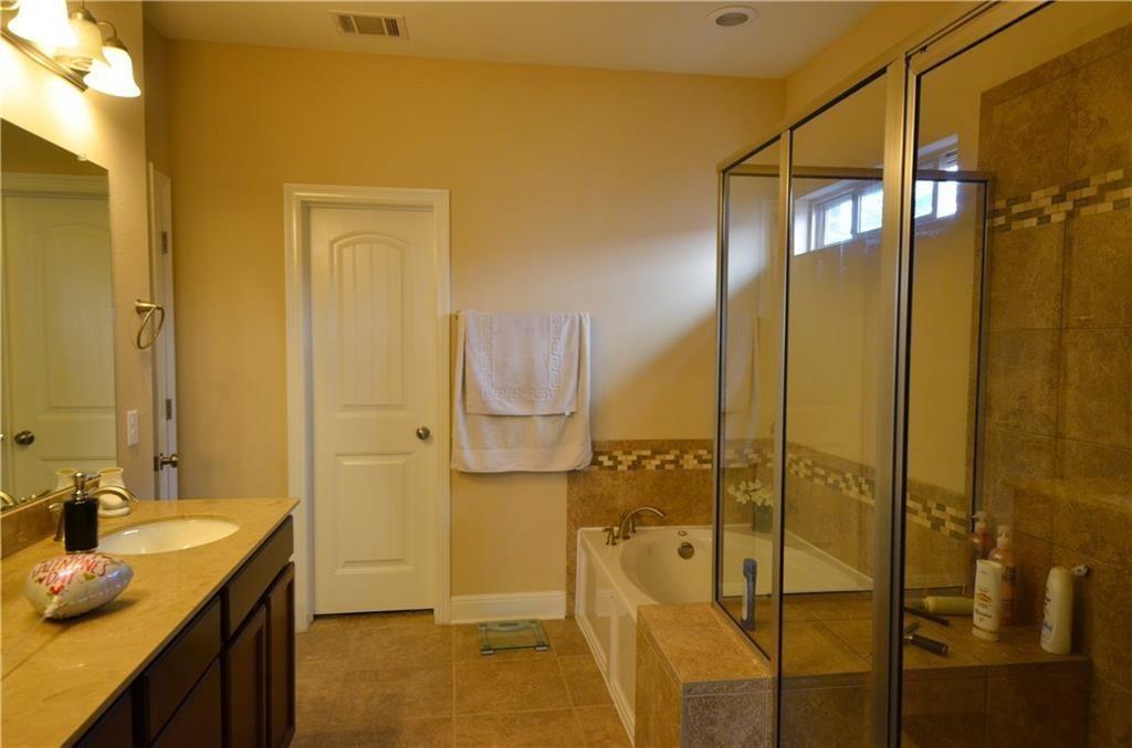 5629 Rio Chama Cove Austin, TX 78738 - Photo 14 of 34 Indulge in a tranquil bathing experience with a luxurious soaking tub and a spacious glass-enclosed shower.