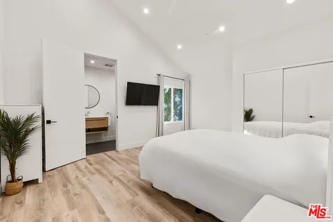 a bedroom with a bed and a flat screen tv