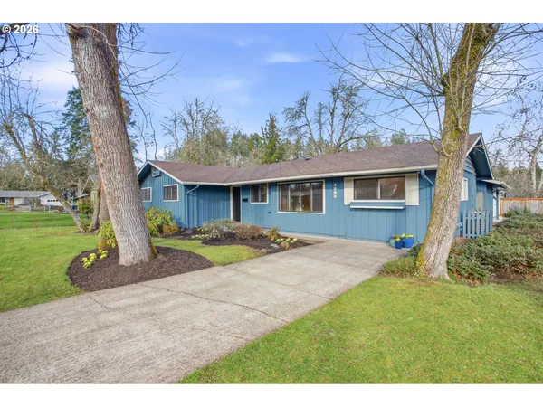 a view of a house with a yard and tree s