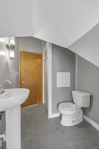 a bathroom with a sink a toilet and mirror