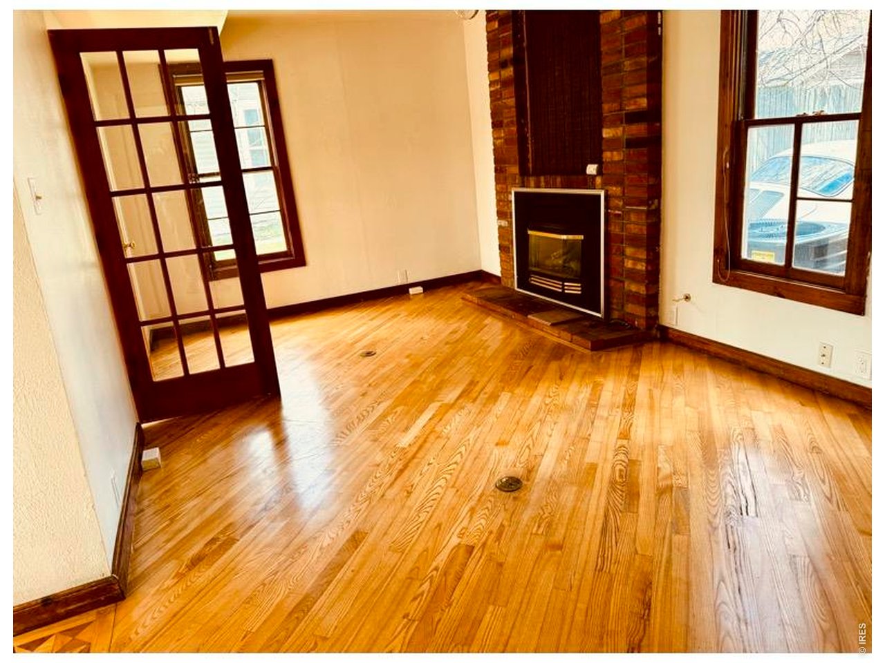 1815 17th Street Boulder, CO 80302 - Photo 5 of 8 a view of an empty room with wooden floor and a fireplace
