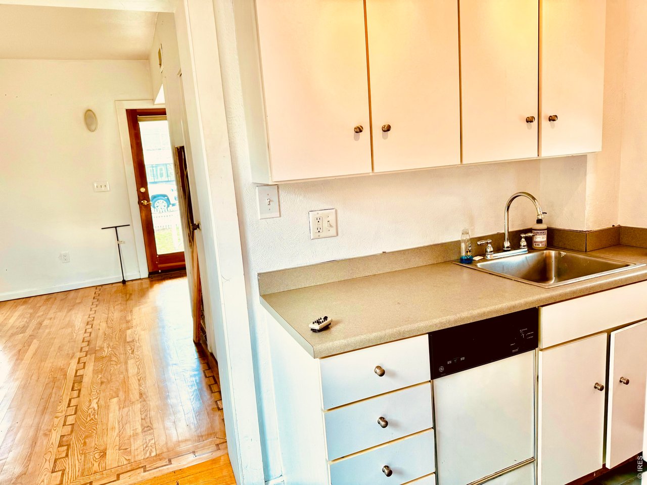 1815 17th Street Boulder, CO 80302 - Photo 7 of 8 a kitchen with stainless steel appliances a sink a stove and white cabinets with wooden floor